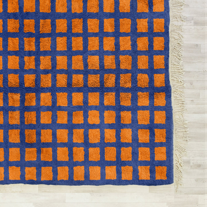 A shag Moroccan Beni Ourain Orange and Blue checkered rug