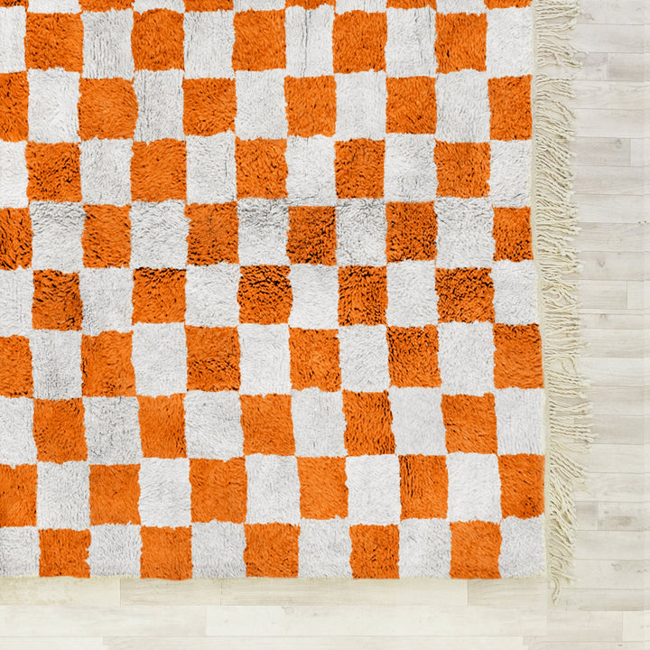 A shag Moroccan Beni Ourain Orange and White checkered rug