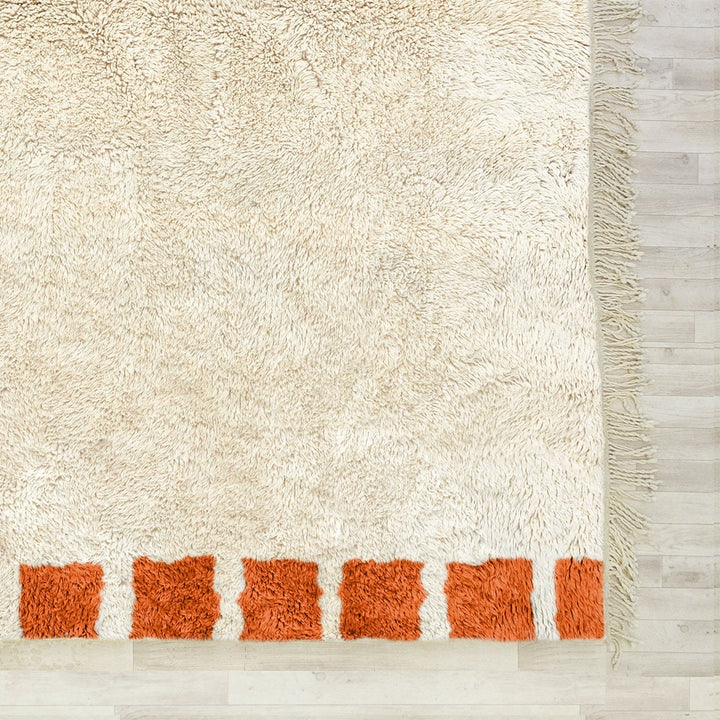 A sheepskin Beni Ourain Moroccan Orange and White checkered rug